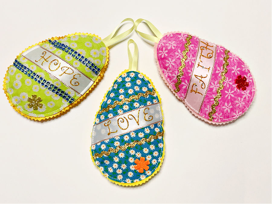 three easter fabric eggs with uplifting messages written on them hope love faith
