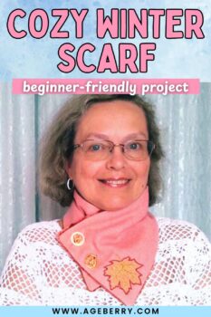 Woman wearing a soft pink winter scarf with button closure and embroidered leaf detail, shown against a light curtain background, with text reading “Cozy Winter Scarf” and “beginner-friendly project.”