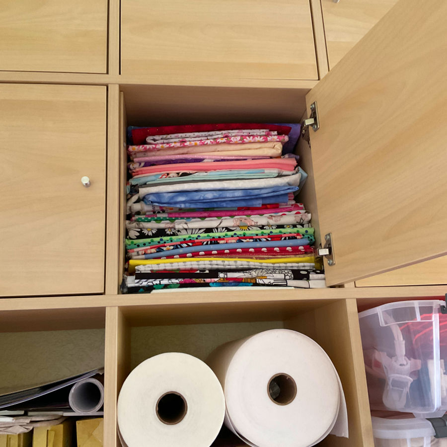 fabric in storage inside a cabinet with doors