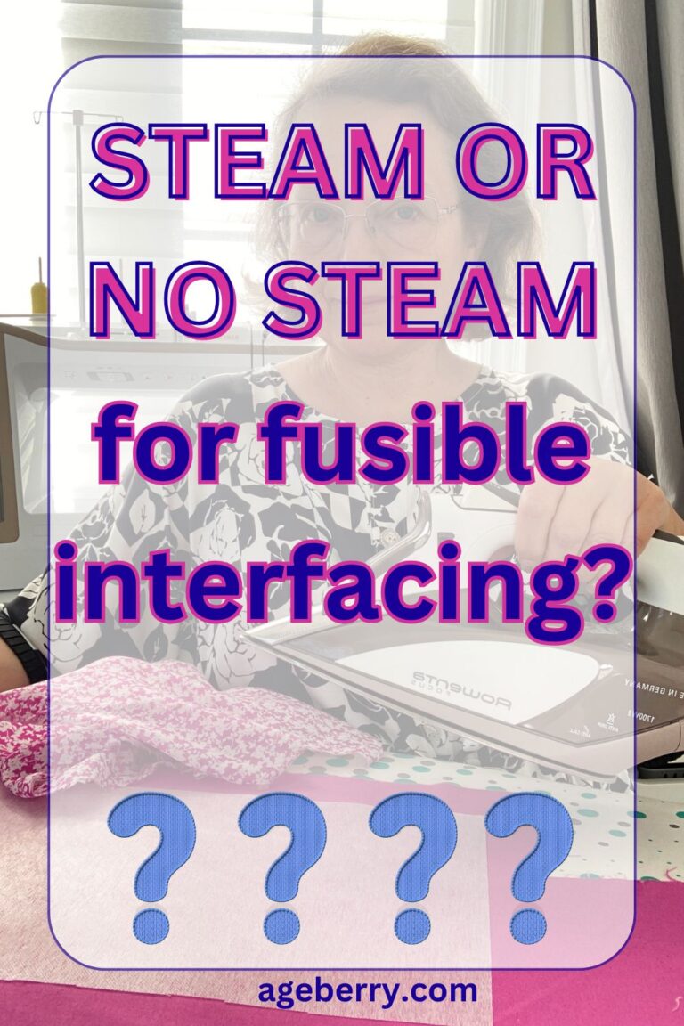 Woman sitting at a sewing table holding a steam iron above pink floral fabric with white fusible interfacing underneath. Large bold text overlays the image reading “Steam or No Steam for fusible interfacing?” Several blue question marks appear at the bottom, and the website ageberry.com is displayed below. A sewing machine and thread stand are visible in the background