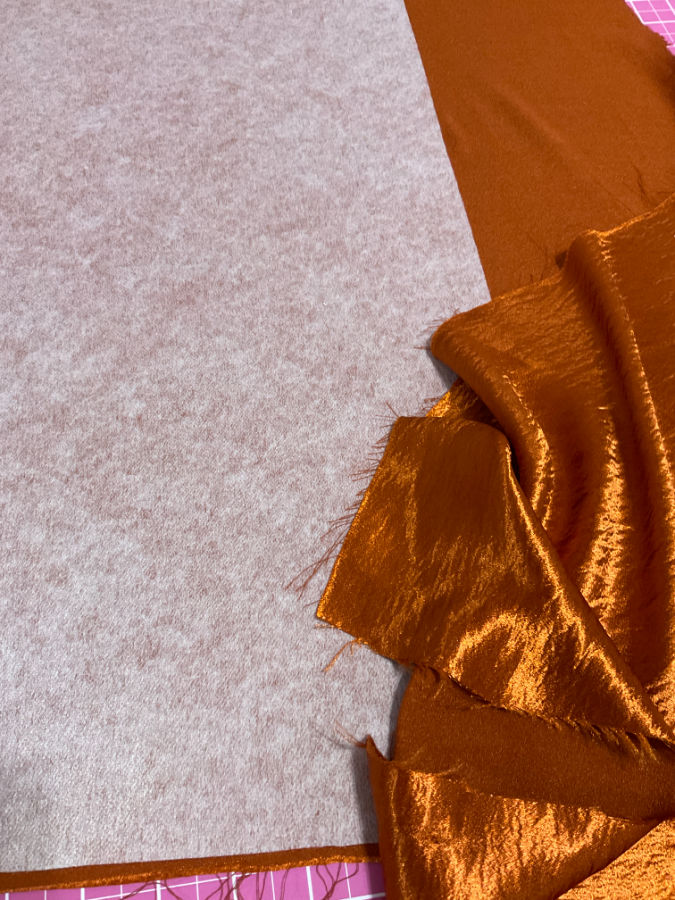 interfacing applied on the wrong side of a shiny material in preparation for sewing