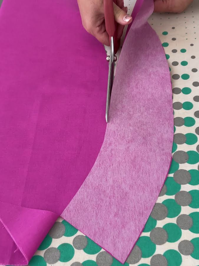cutting the pattern piece from the fabric after the piece of interfacing is fused using the interfacing as a pattern