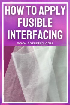 Close-up of several pieces of white and light-colored fusible interfacing layered over pink fabric on a flat surface. The image features a purple gradient background with large white text at the top reading “How to Apply Fusible Interfacing” and the website ageberry.com below. The interfacing sheets are slightly translucent, showing texture and thickness differences