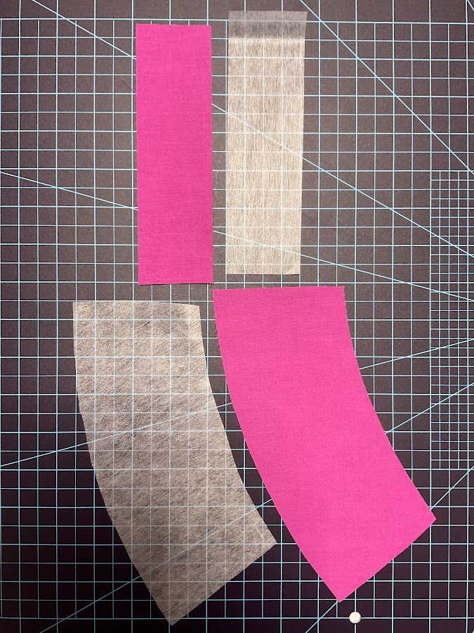 pieces of interfacing and fabric of identical shape and size arranged on a cutting mat