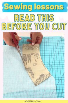 Teal and yellow header reading “Sewing lessons” with large text “READ THIS BEFORE YOU CUT.” Below, hands cut a paper pattern piece pinned to white interfacing using red scissors on a blue grid cutting mat. The bottom border shows AGEBERRY.COM