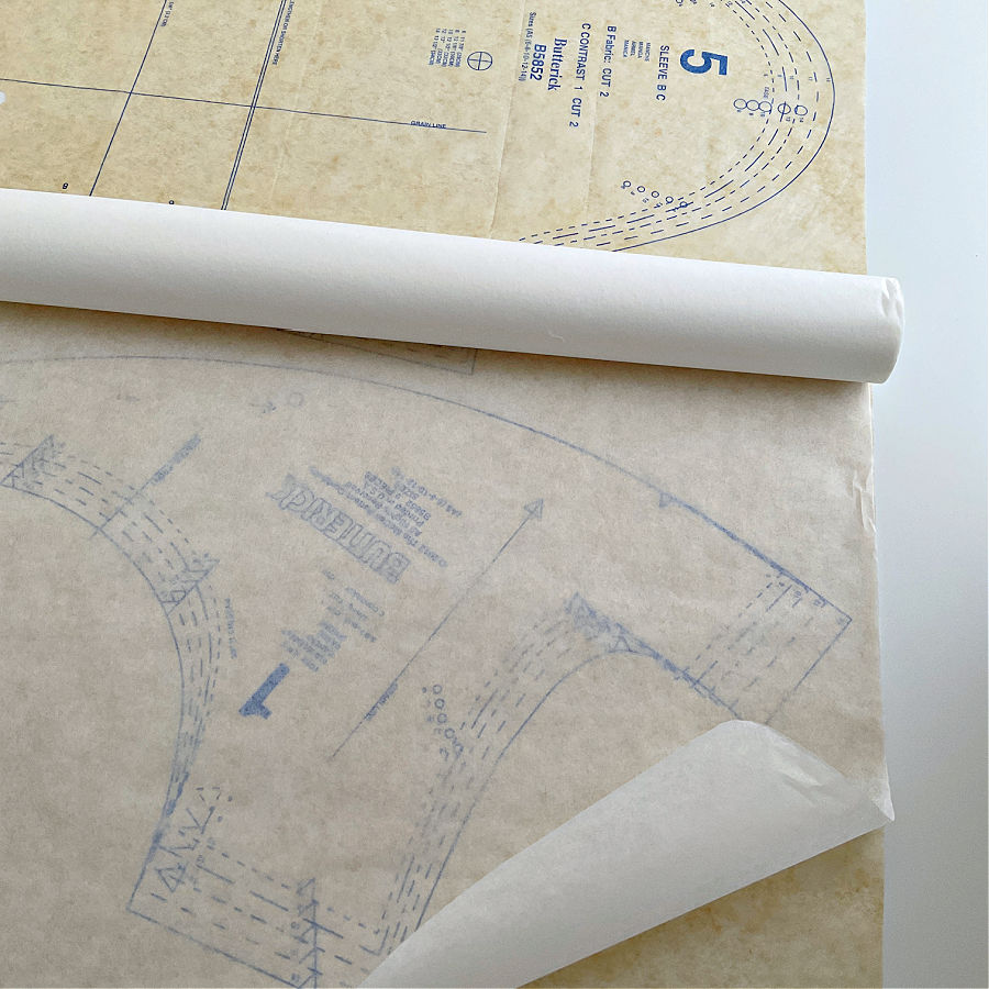 a roll of medical exam paper on top of a pattern piece in preparation for transferring the pattern to paper