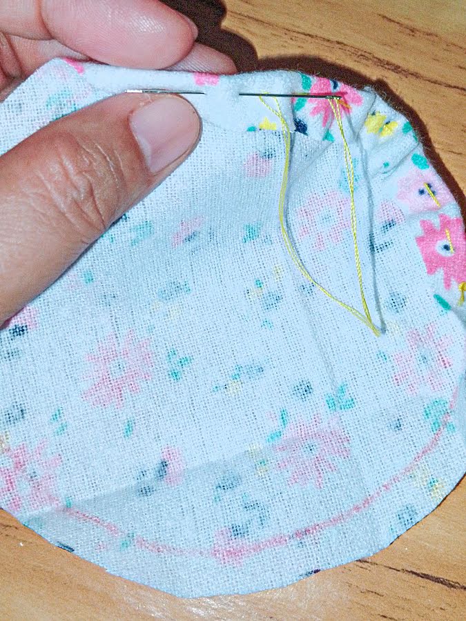 Hand-sew loose basting stitches around the folded edge of the circular tail fabric, keeping the stitches even so the fabric can be gathered.