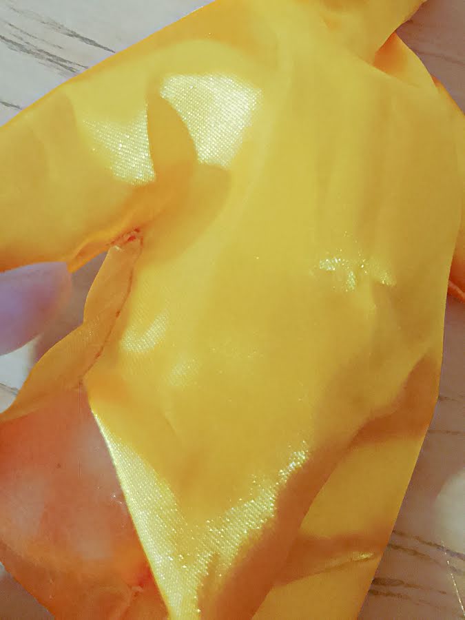 Close-up of stuffing being pushed into a narrow area of the soft toy, such as an arm or corner, to fully shape the edges before filling the center.