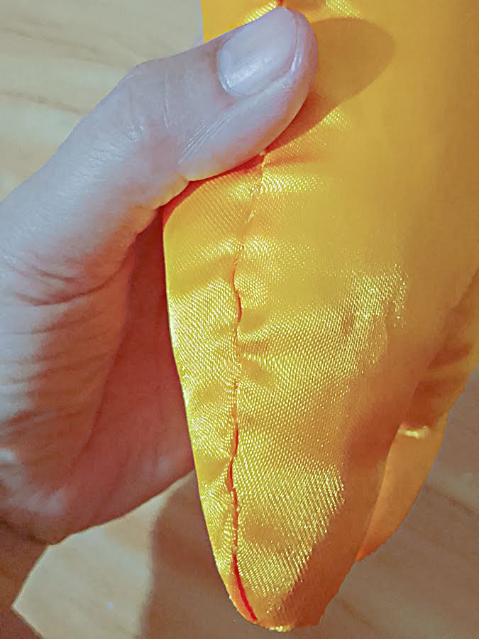 Soft toy body after the opening has been closed, showing a smooth side seam where the ladder stitch blends into the surrounding fabric.