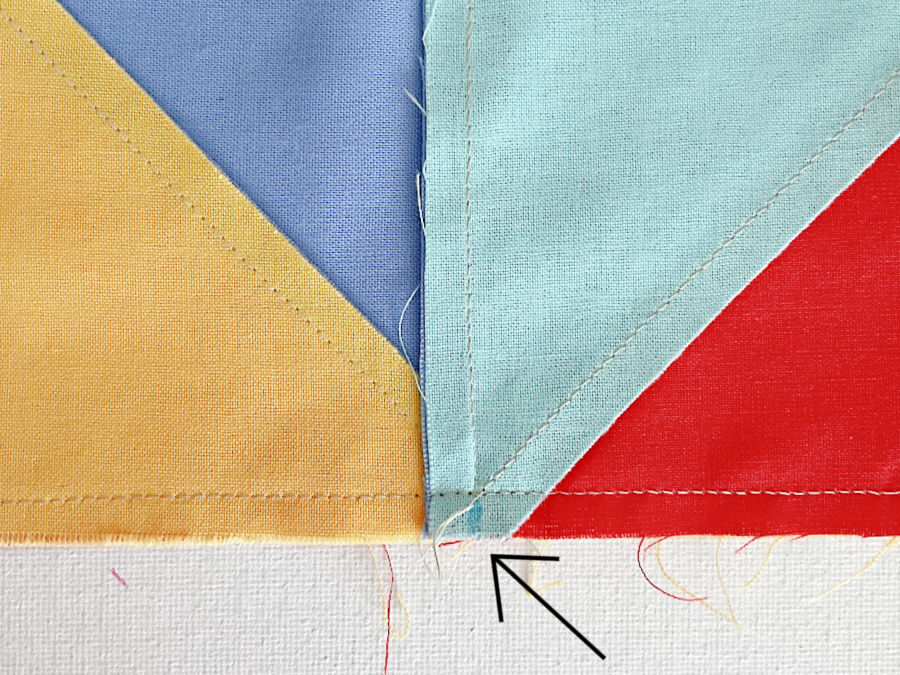 arrow shows where a couple of stitches are removed on one side in preparation for reducing the bulk in the center