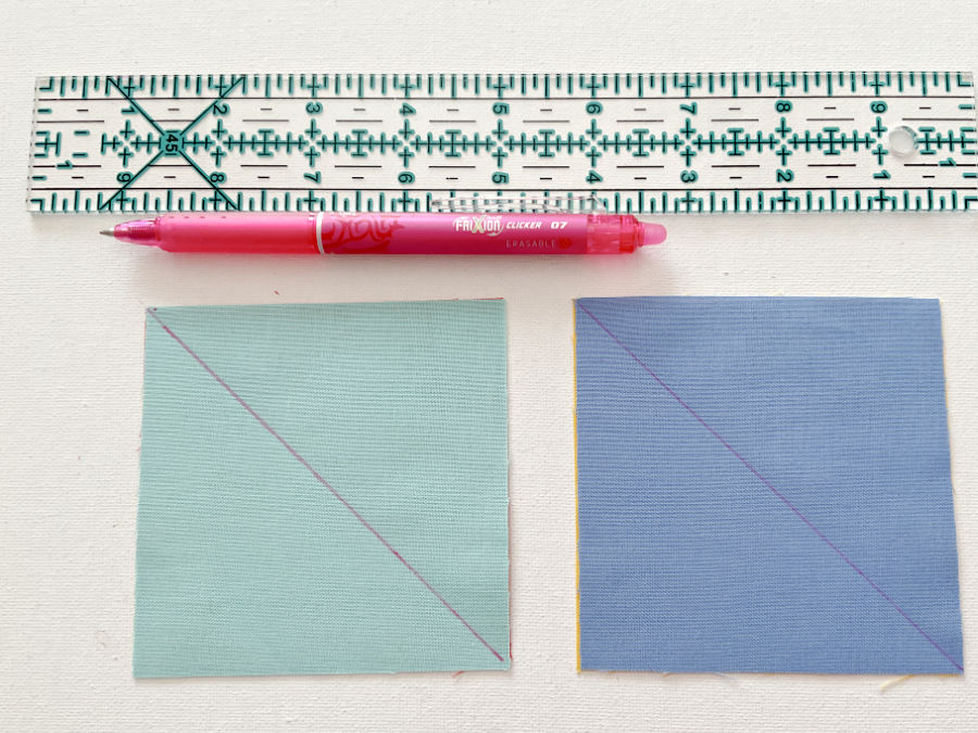 frixion clicker erasable pen and two fabric squares having lines marked on one diagoinal