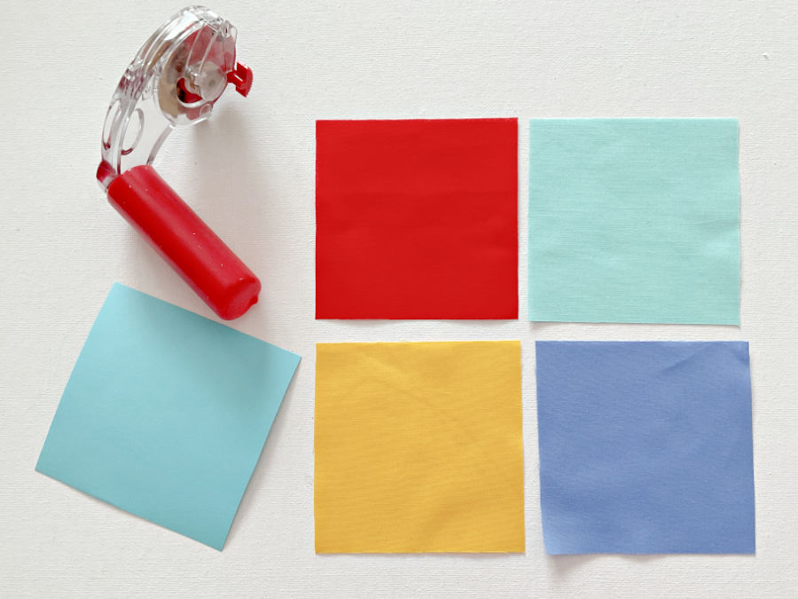 square paper template rotary cutter and four fabric squares of various colors