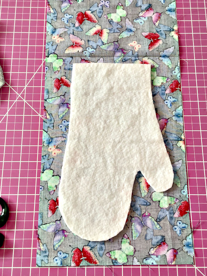 The second batting piece arranged ion a mirrored position on the mitt fabric