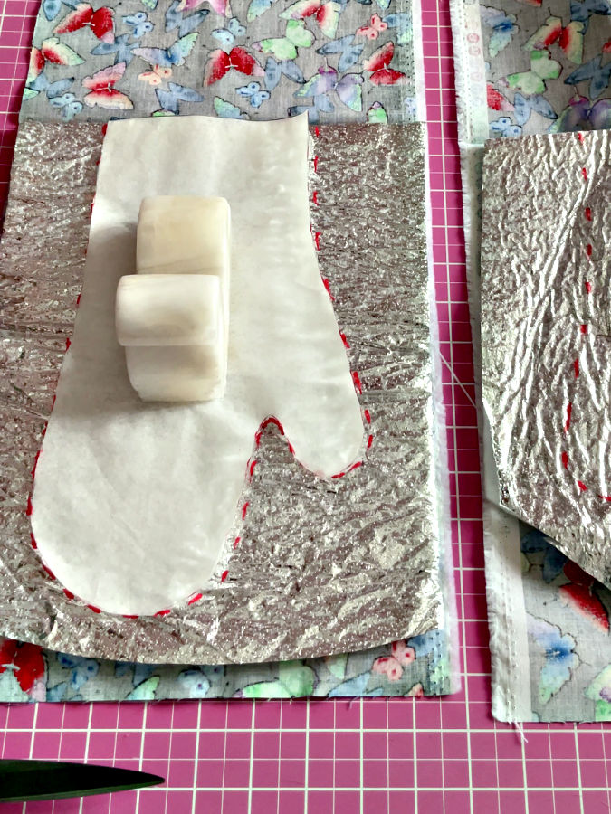 the paper pattern placed on top of the thermal batting and secured with a pattern weight in preparation for marking