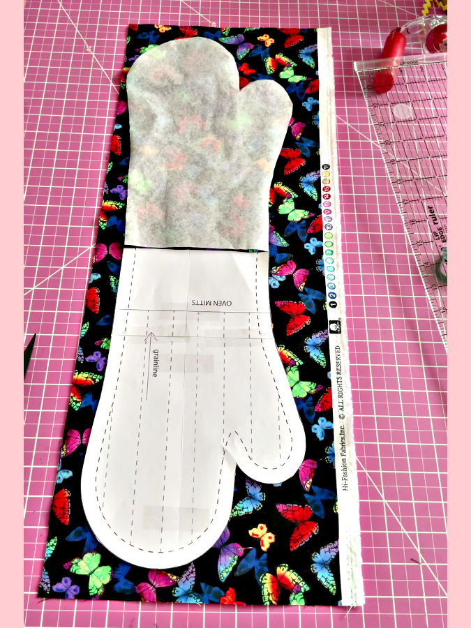 The paper patterns arranged to allow cutting of the fabric rectangle for the oven mitt