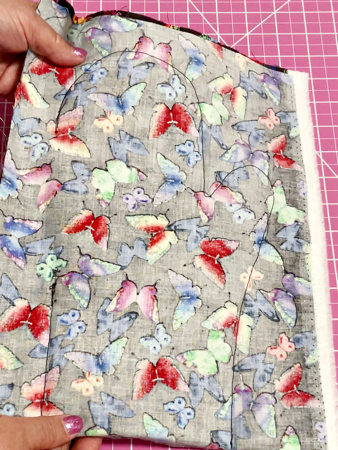a womans hand showing mitten shape after stitching the opening on the left side still visible