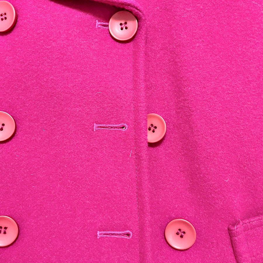 Pink wool coat front with matching buttons and horizontal keyhole-style buttonholes.