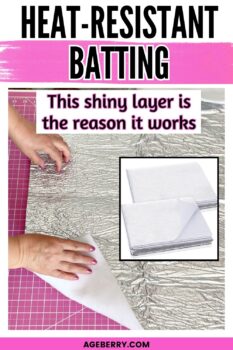 Hands lifting a piece of heat resistant batting with a shiny reflective layer on a pink cutting mat, showing the silver side and white backing