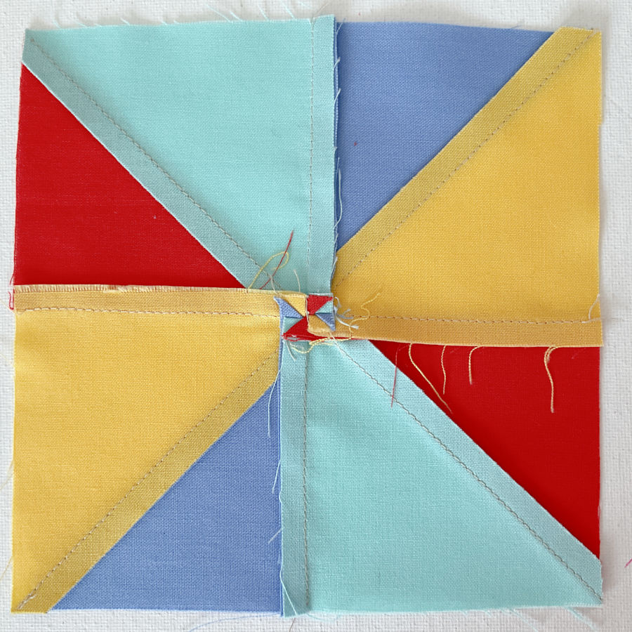 showing how the seam allowances are spread in the center to avoid bulk a small pinwheel appears