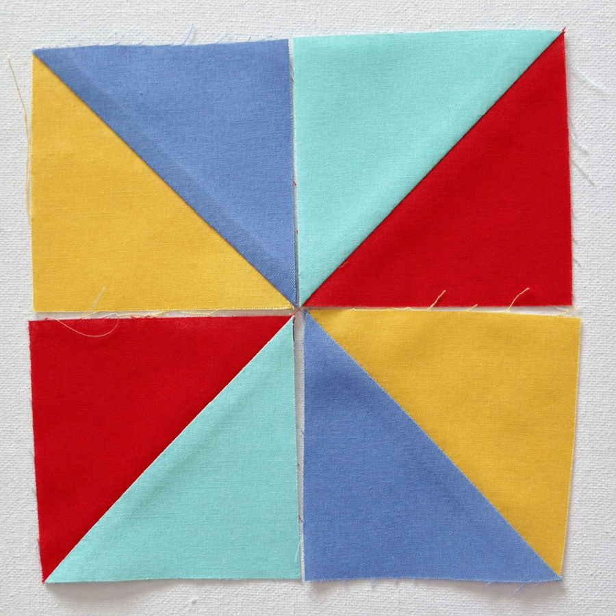 four half square triangles arranged in such a way that the pinwheel pattern becomes apparent