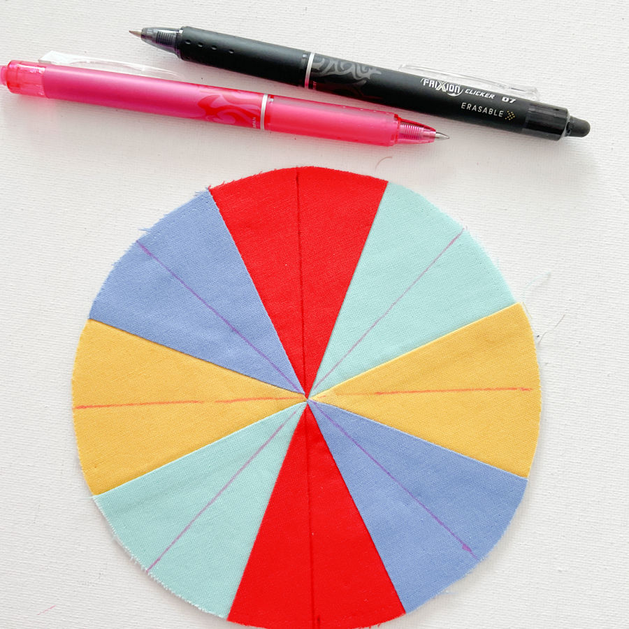 two frixion pens and the circle of material with lines marked through the center of each color section