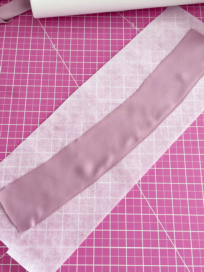the whole strip of stabilizer is shown attached to the material of the dress that needs to be hemmed