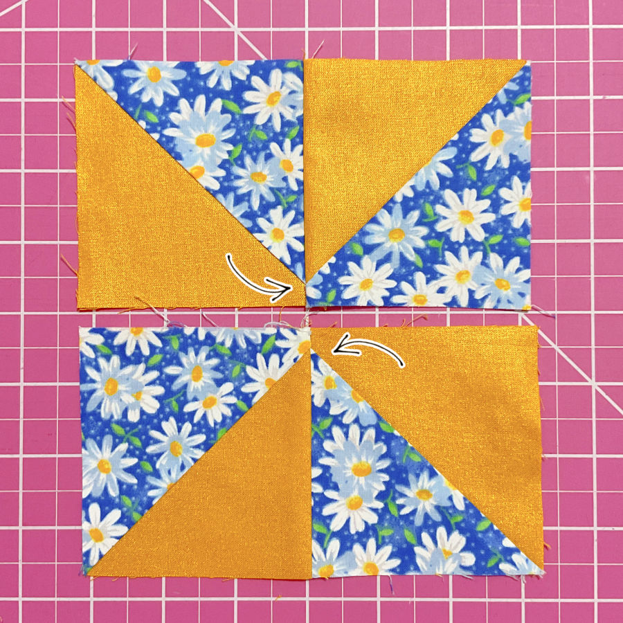 two rectangular blocks each made out of two half square triangles sewn together seen from the right side the seam allowance for the final stitch visible arrows point to the center points which will need to match