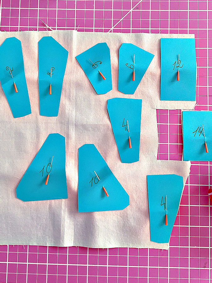 pattern pieces pinned to fabric for cutting one piece already cut