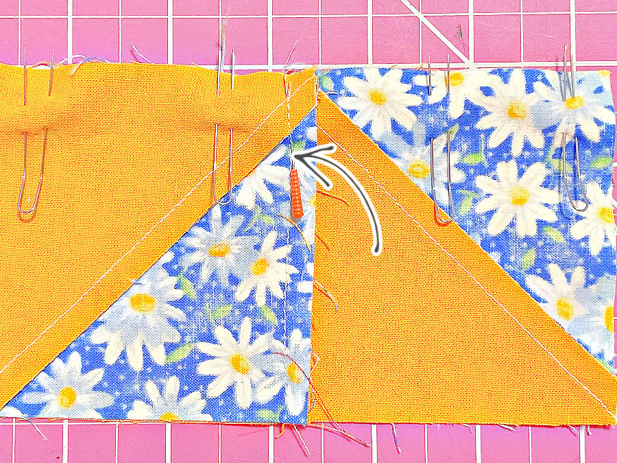 two half square triangles pinned together with fork pins and in the middle where the material is thicker with a regular pin