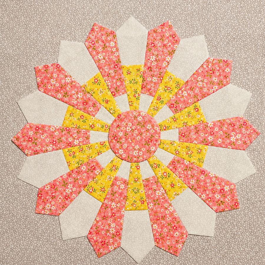 dresden plate quilt block in yellow pink and white colors with a floral motif
