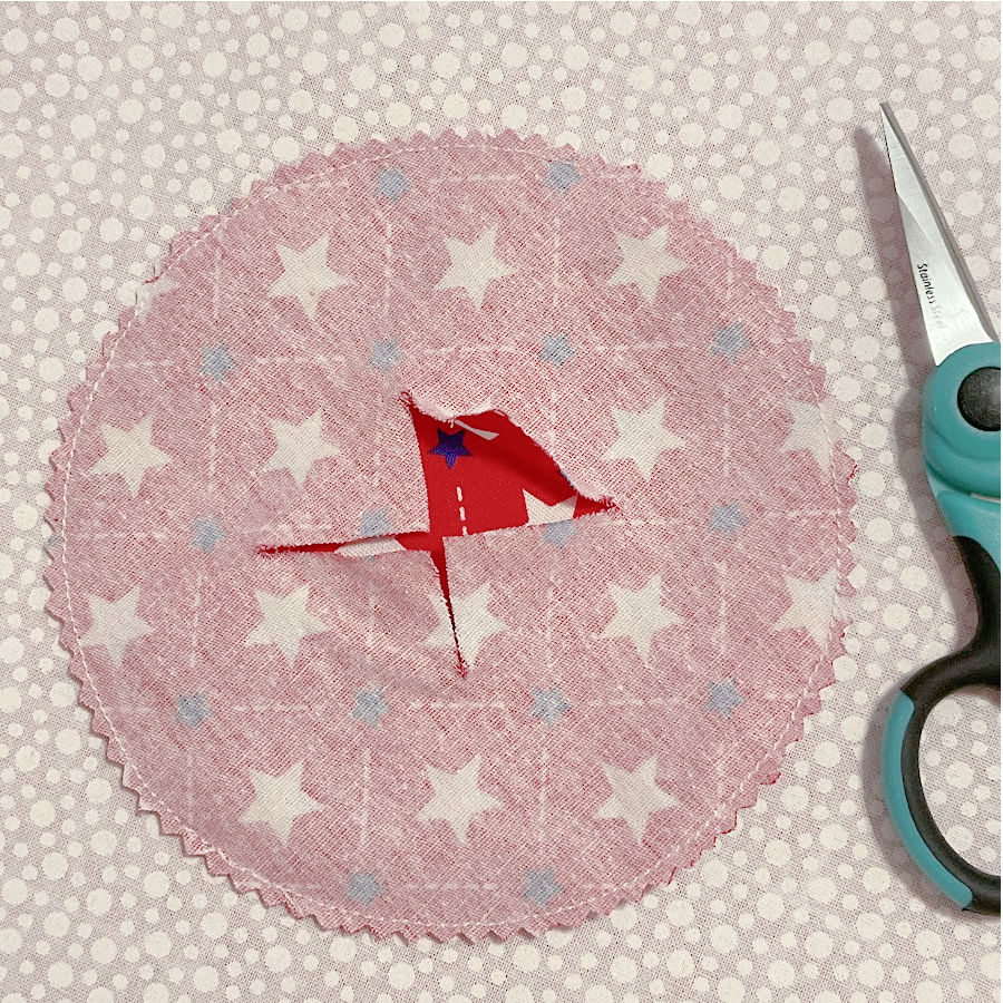 the red fabric circles showing the center cut also the seam allowance is shown cut with pinking shears all around