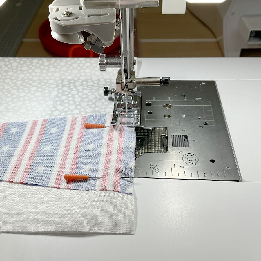 sewing machine needle assembly while stitching the blue blade to the white rectangle with a 1/4 inch seam allowance