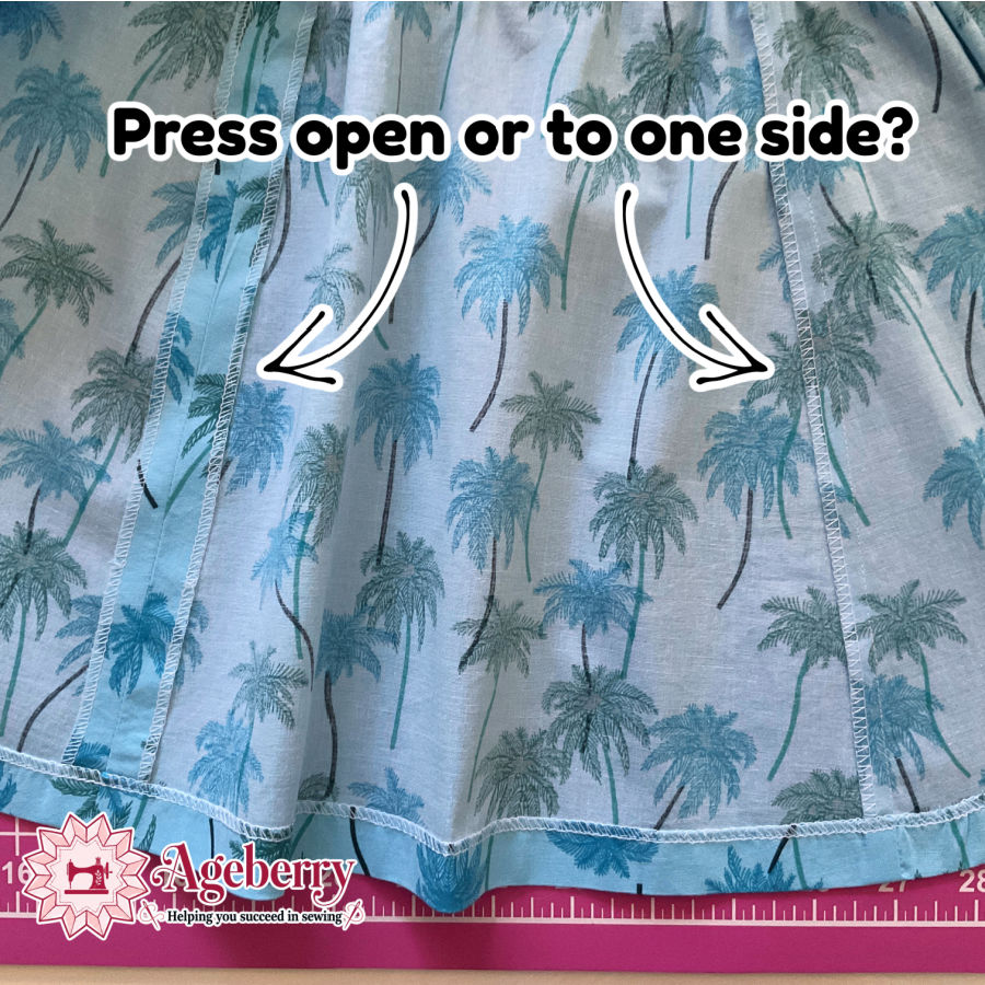 a closeup of a finished garment probably a skirt showing two seams one pressed open and one pressed to a side arrws point to the two seams
