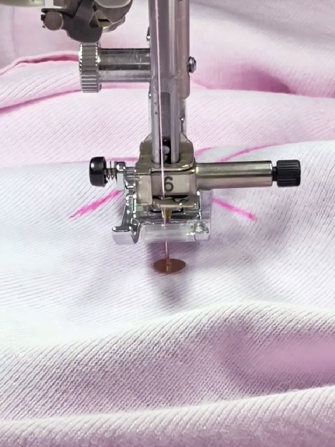 a sewing machine needle sewing over a sequin piece