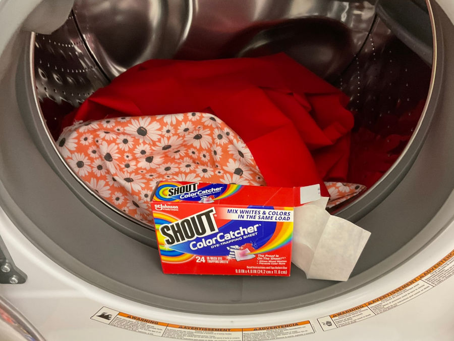 color catcher sheet box in front of a washing machine with clo0thes inside