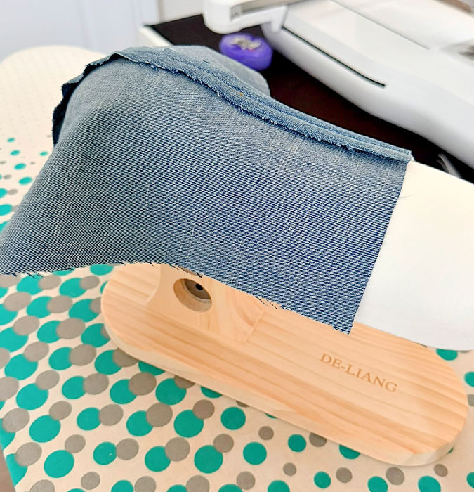 image of a piece of denim with a princess seam draped over the corset ironing tool wider angle