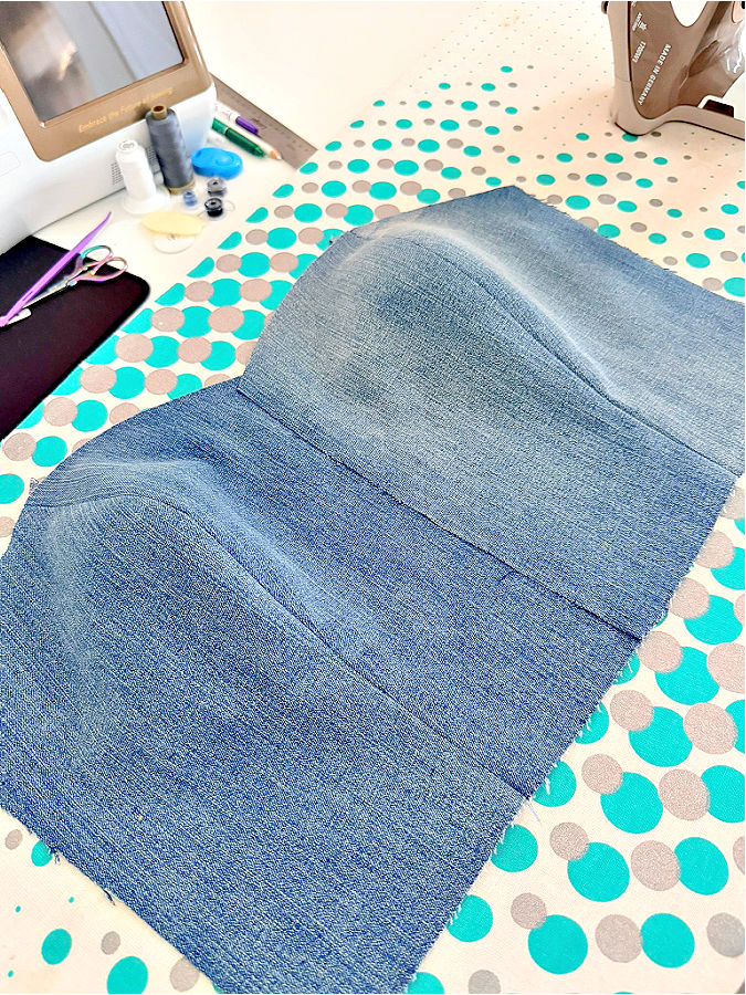 two pieces of denim side by side both having a princess seam on an ironing board