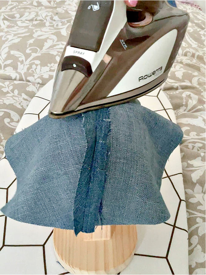 a rowenta hot iron while ironing a piece of denim o the corset ironing board