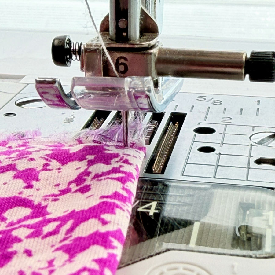 sewing machine pulls fabric into throat plate