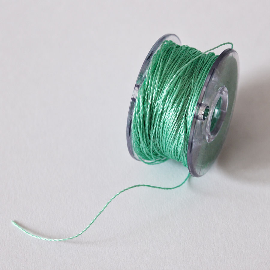 image of a sewing machine bobbin unevenly wound