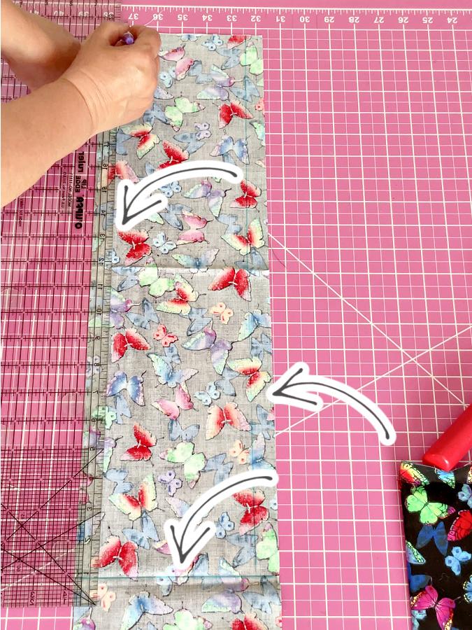 a woman is marking sewing lines on the wrong side of one of the fabric rectangles three arrows point to the lines