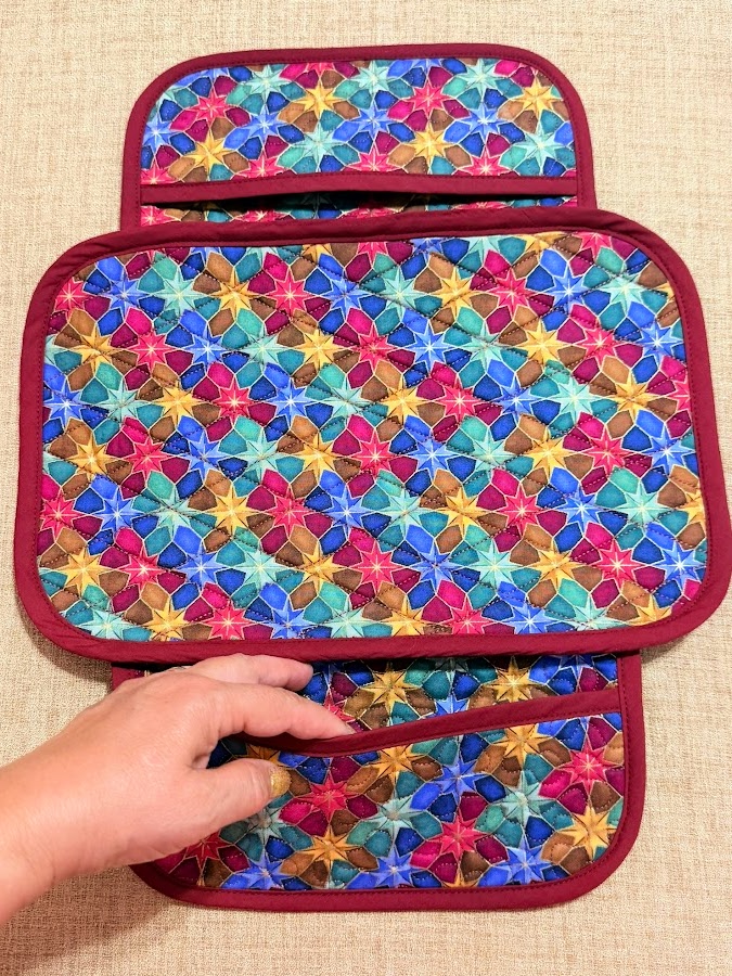 a womans hand showing a pocket of the organizer which is laid flat on a table