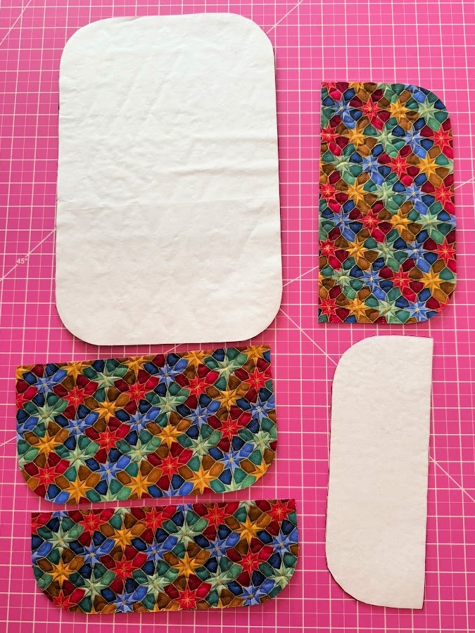 the pattern pieces cut from the fabric panel some of them still have the freezer paper attached