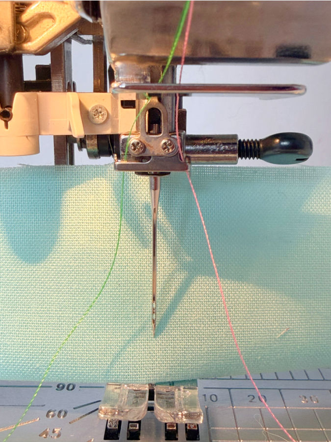 close up image of the janome needle assembly with two thread paths near the needle