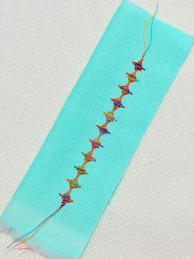 decorative stitch made using a double eye needle, a solid color thread and one variegated color thread