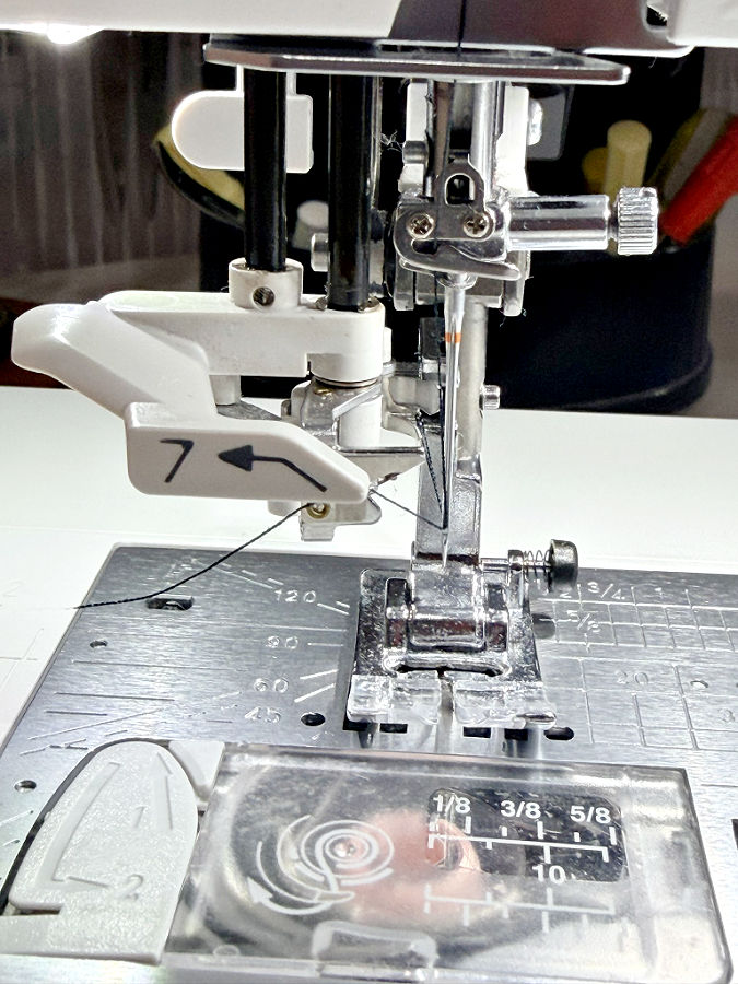close up image of the automatic needle thrteader on a modern sewing machine