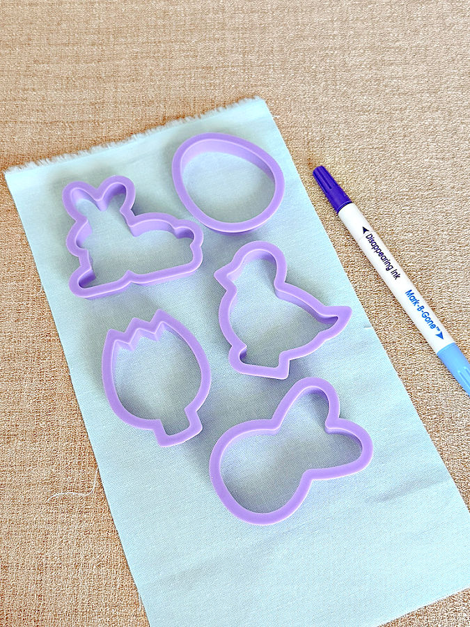cookie cutting shapes on a piece of material a marking pen nearby
