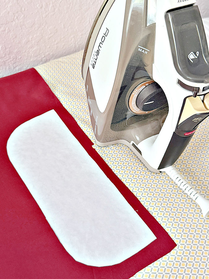 a piece of freezer paper temporarily attached to a piece of fabric using a hot iron which sits nearby
