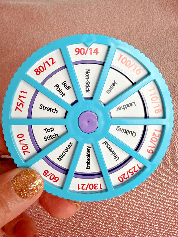 a womans hand holding the needle noter