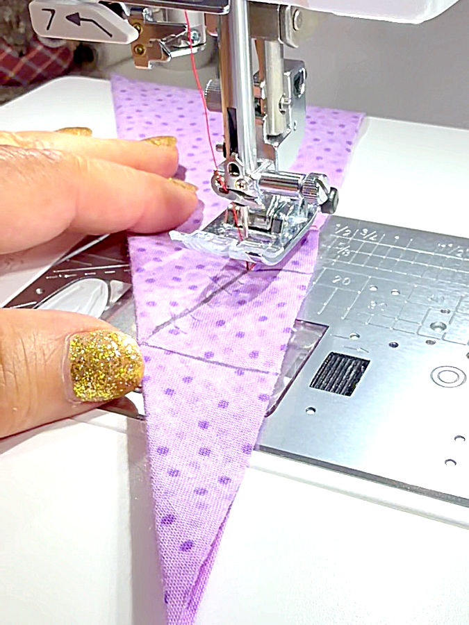 a womans hand arranging the fabric on a sewing machine before sewing